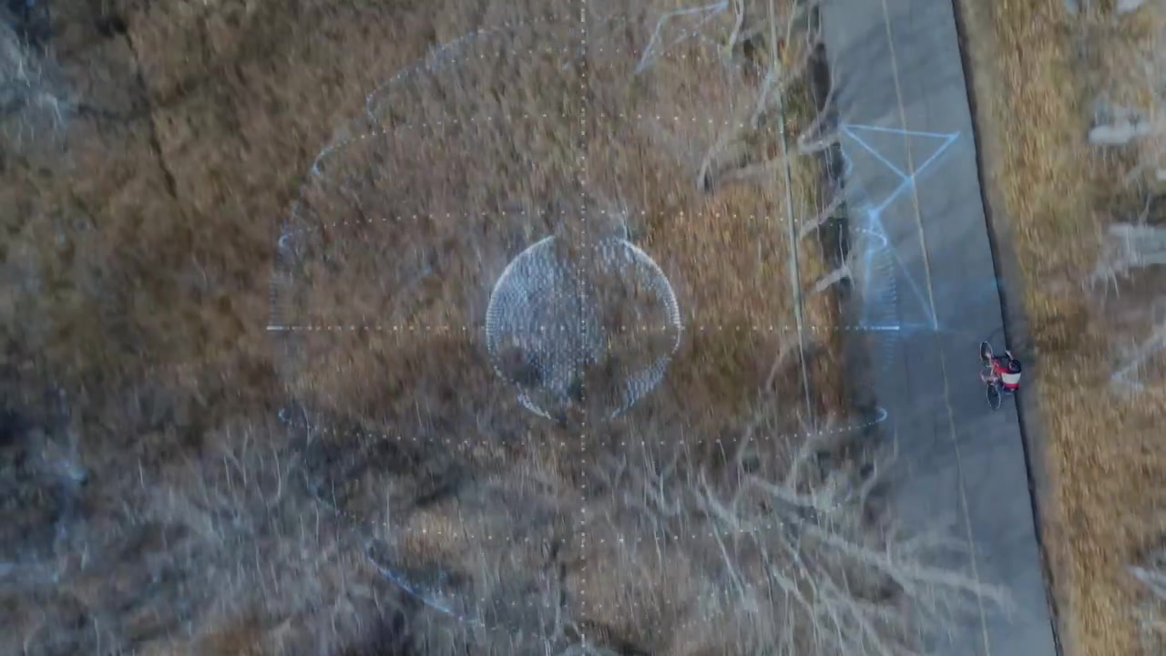 Pulsing dotted sphere sending arcs toward trail as cyclist riding past, camera panning, showing art