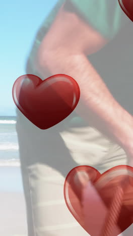 animation of hearts falling over caucasian family at beach