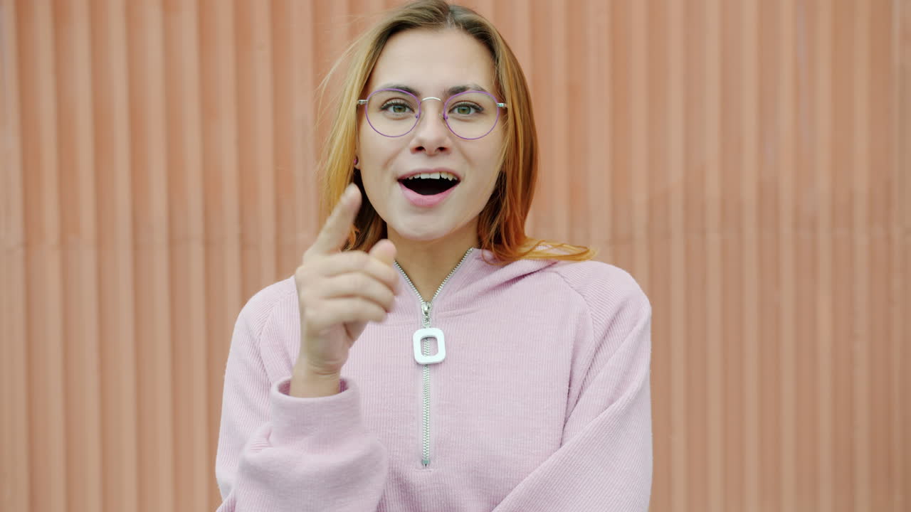 Young Woman in Pink Hoodie with Glasses