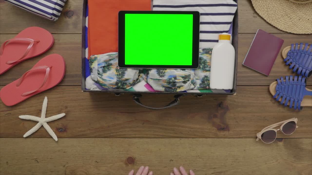 antena aérea de una mujer colocando una botella de protector solar en una maleta