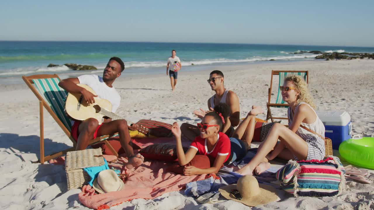 jóvenes amigos adultos pasando el rato juntos en la playa 4k