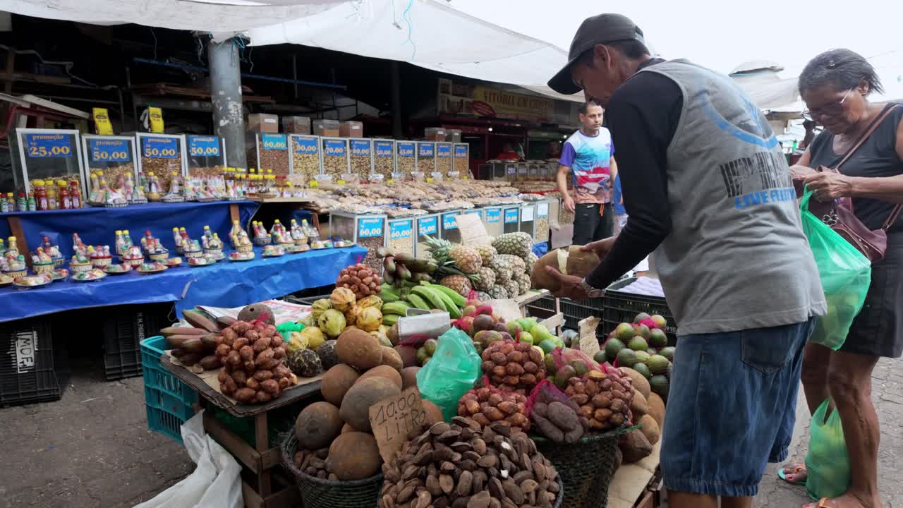 Brazil, Belem, The Ver-o-Peso Market and Surroundings: A fruit vendor preparing a coconut for sale, showcasing the vibrant market life and traditional practices. A glimpse daily commerce and flavors