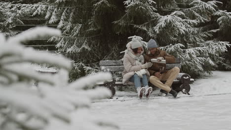 couple enjoying hot drinks on a snowy winter day