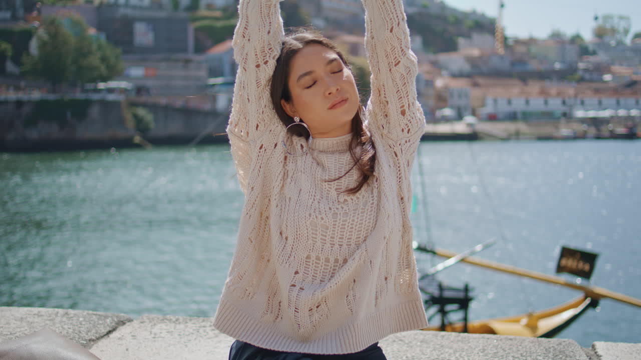 Carefree model stretching hands sunbeams river view zoom on. Lazy  woman