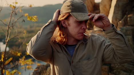 guy with long blond hair putting up cap and smoking his cigarette peacefully, vogelberg