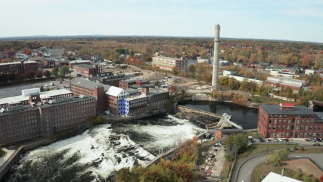 saco river dam, falls and old merc smokestack in biddeford, drone shot