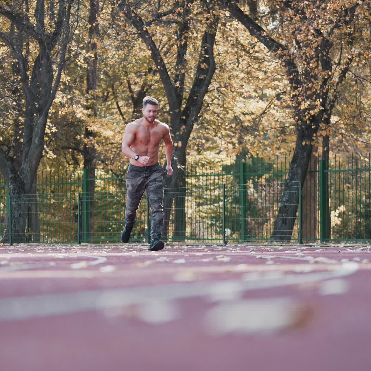 Muscular man is training on outdoor stadium. Young sportsman without shirt running during his workout on athletics track. Healthy lifestyle.