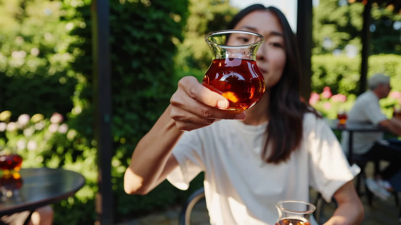 Donna che si gode il tè in un caffè con giardino