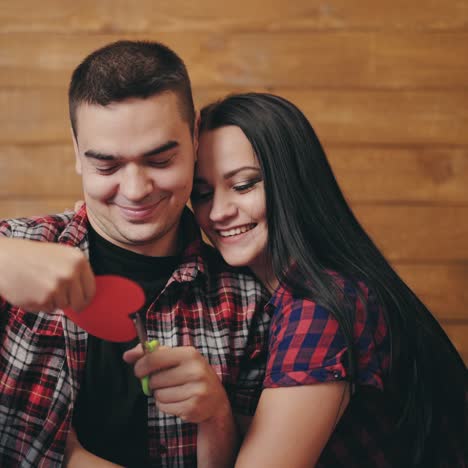 a man is carving out heart with colored paper in the arms of a beloved woman on valentine's day