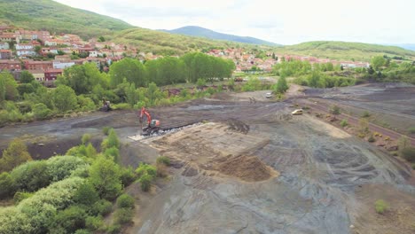 excavator with hydraulic hammer breaking concrete, aerial view