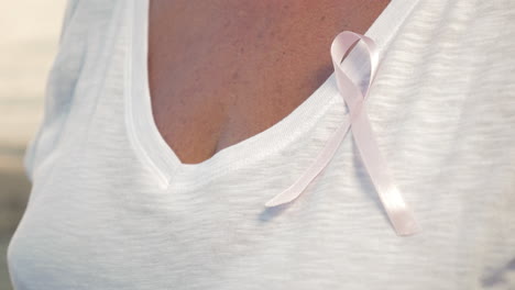 senior woman wearing pink awareness ribbon