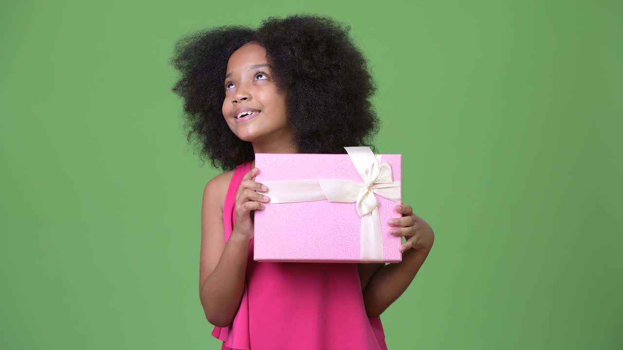 joven africana con cabello afro sosteniendo una caja de regalos