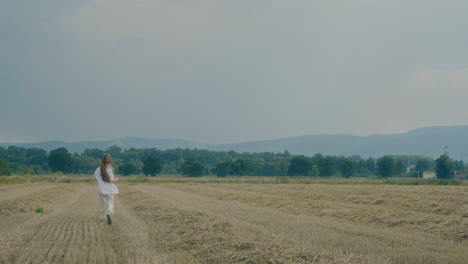 hapy woman running on harvested field