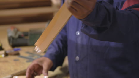 closeup of a woodworker assembling a wood chair frame, furniture manufacturing industry
