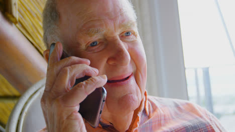 close-up of caucasian senior man talking on mobile phone in a comfortable home 4k