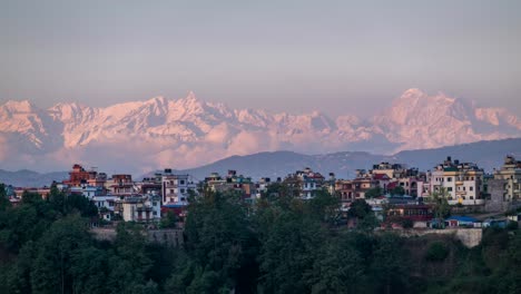a time-lapse of the sun setting over the himalaya mountains and the city of kathmandu, nepal.