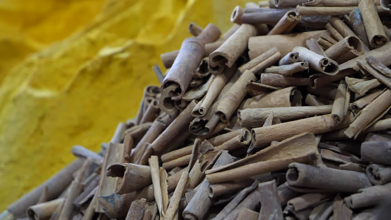 Messa a fuoco selettiva su spezie in un mercato marocchino, bastoncino di cannella e curcuma in polvere