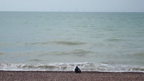 person sitting alone by the sea