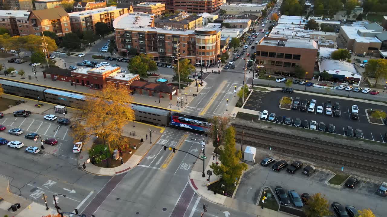 Commuter train crossing through Downers Grove Illinois train station at sunset. Crane Down Sunset S