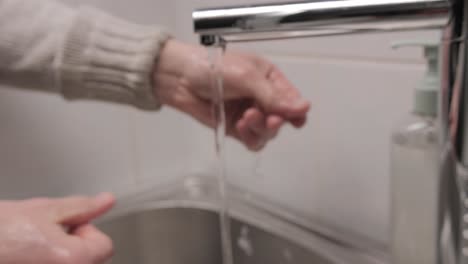 hombre lavándose las manos con jabón líquido en el baño