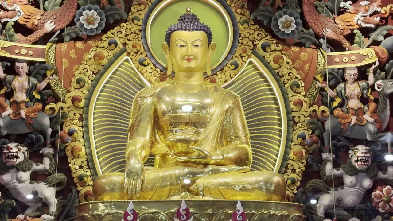 Statua gigante di Buddha si erge maestosamente all'interno di un monastero, mostrando un'espressione serena e dettagli intricati in un ambiente spirituale interno.