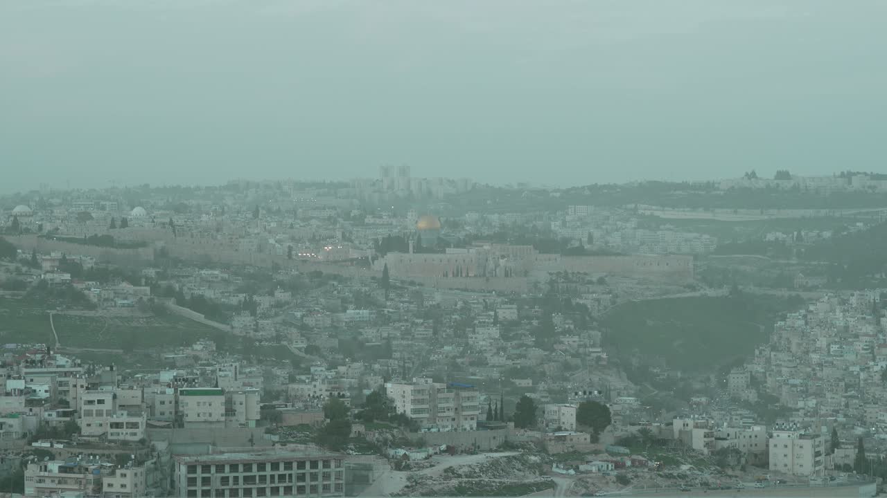 Veduta cinematografica delle storiche mura della Città Vecchia, della Cupola della Roccia e del Monte del Tempio a Gerusalemme. Uno sguardo al sito sacro per l'Ebraismo e l'Islam, ripreso durante una giornata nebbiosa con scarsa visibilità