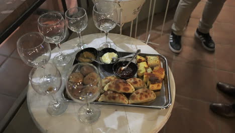 appetizer with empanadas and paraguayan soup served on white table at reception party. argentine gastronomy, close up