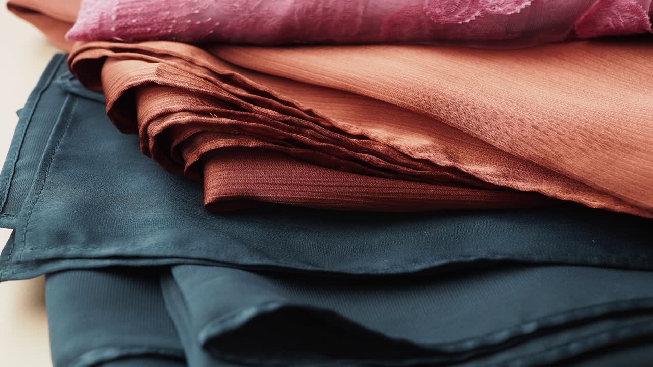 primer plano de telas de lujo en varios tonos de rojo, naranja, rosa y verde