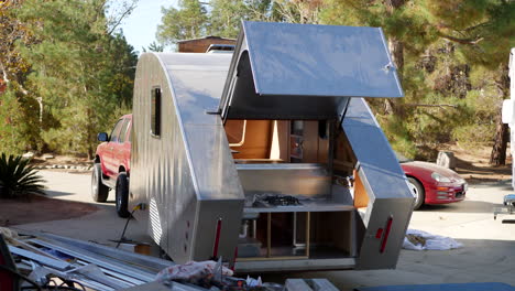 slide left along a construction site where they are building a metal custom teardrop travel trailer to take on a camping roadtrip