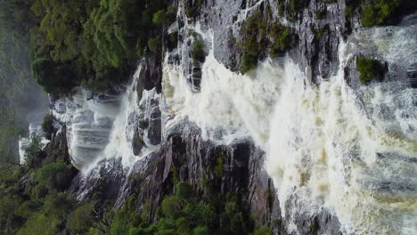 aerial view over the colnett waterfall in middle of forests and mountains, new caledonia