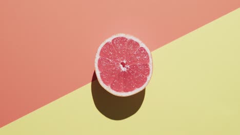 video de pomelo rojo en rodajas con espacio de copia sobre fondo naranja y amarillo