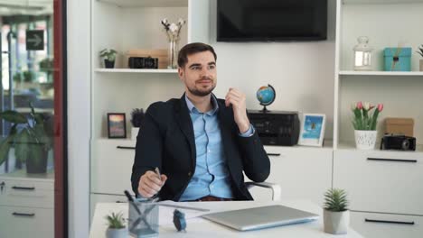 The-young-charismatic-man-is-writing-something-down-on-a-sheet-of-paper