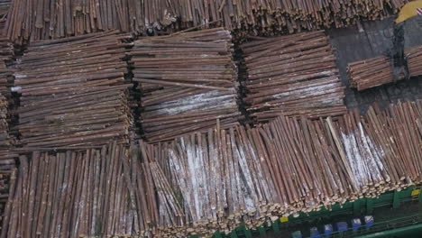 aerial parallax shot over a ship with timber, hydraulic gripper machine loading tree logs