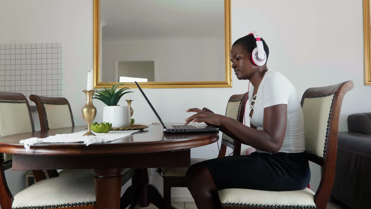 African lady working from home wearing earphones