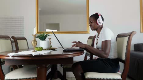 african lady working from home wearing earphones