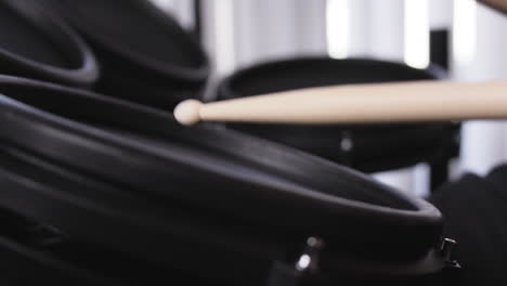 Close-up-of-drum-sticks-bouncing-off-an-electric-drum-in-slow-motion