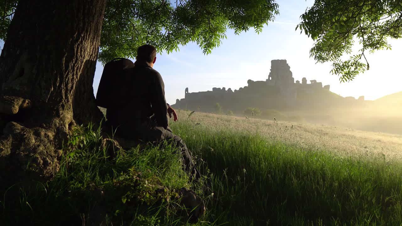 caminante admirando el castillo de corfe al amanecer