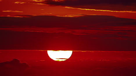 luna brillante detrás de capas de nubes en el horizonte rojo