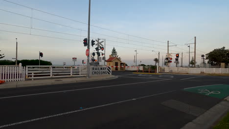 railway level crossing boom gates and red lights flashing.