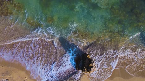 Taking-off-aerial-drone-clip-moving-over-a-sandy-beach-and-a-rock-formation-in-Kavala,-Macedonia,-Greece