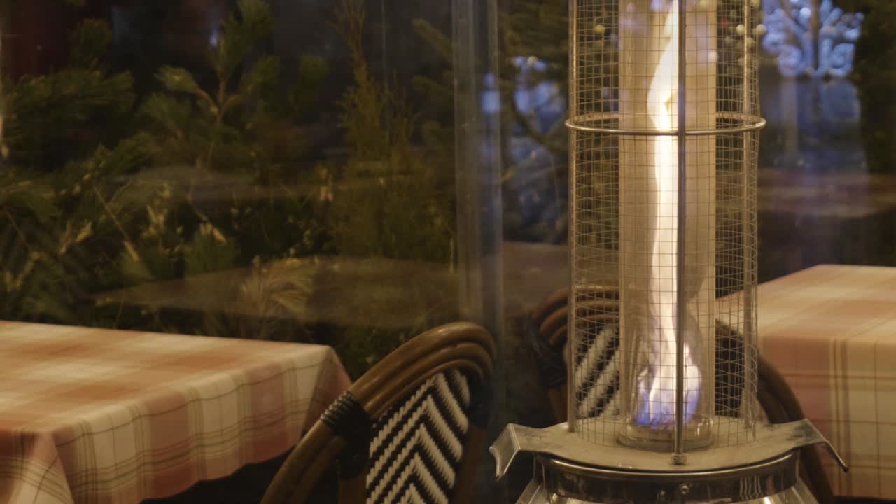 luz de calefacción de patio de llama de gas, vacío cómodo al aire libre jardín de restaurante cálido por la noche, llama ardiente caliente movimiento lento objeto de primer plano, detalle, nadie. simple cómodo área de relajación, fondo de la noche
