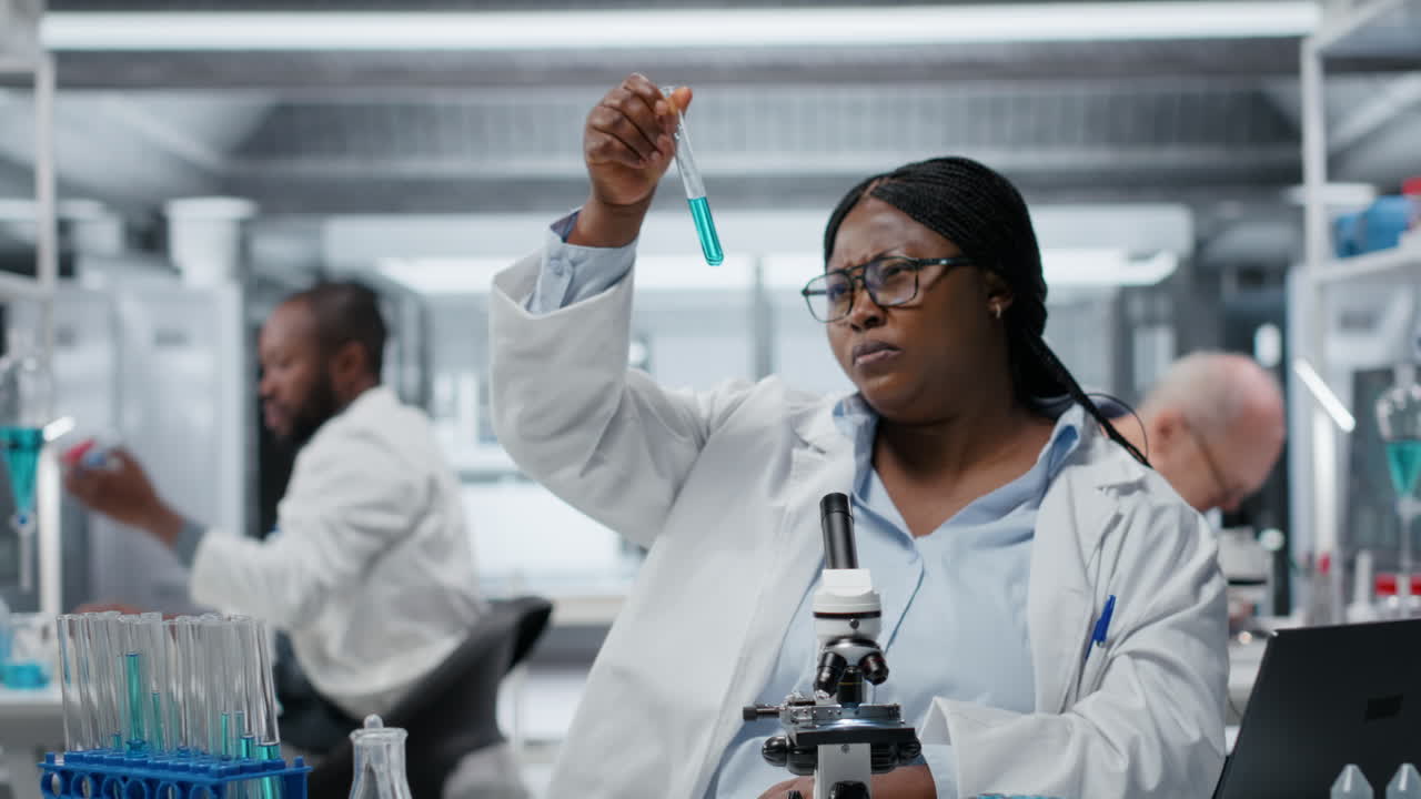 Lab materials scientist investigates blue liquid polymer properties in test tube