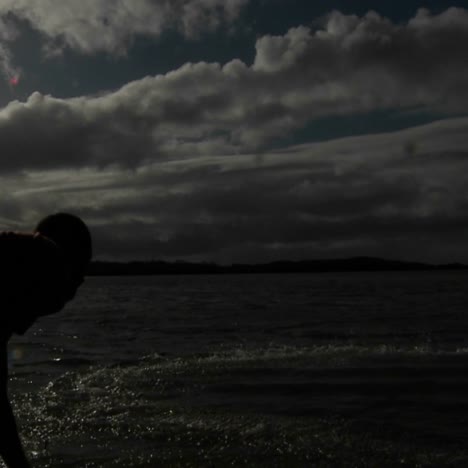 a native fisherman throws his net into the ocean to catch fish in slow motion