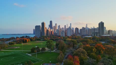 A-drone-reveal-shot-of-the-beautiful-Chicago-skyline-with-a-view-of-Lake-Michigan-and-Lincoln-Park,-filmed-at-sunset