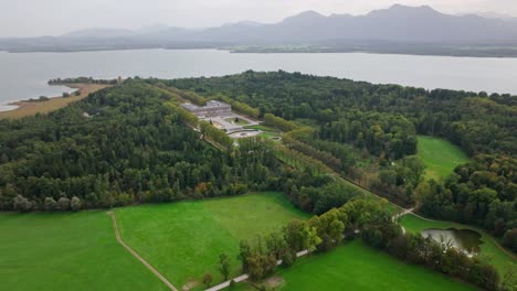 Nuevo-Palacio-De-Herrenchiemsee-Rodeado-De-árboles-Verdes-Junto-Al-Lago-Chiemsee-En-La-Isla-Herreninsel,-Baviera,-Alemania