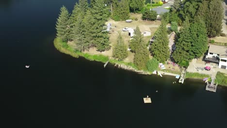 drone flying above a quiet village and lake - aerial shot