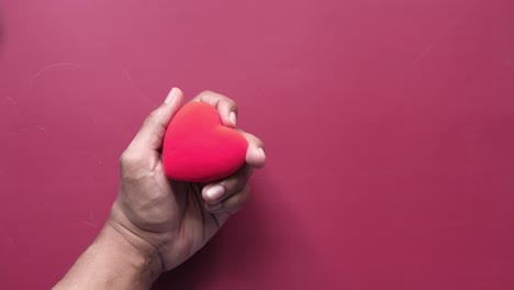 mano con un corazón rojo
