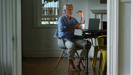 Senior man using laptop at home 4k