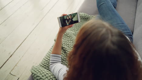woman having a video call on a sofa at home