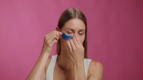 woman applying blue eye patches